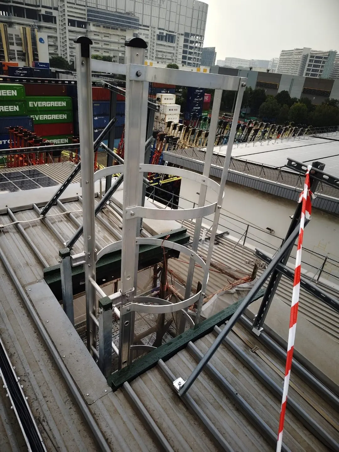 Ancillary building cat ladder add-on at Buroh Street with hoop cage detail and top mounting against the parapet