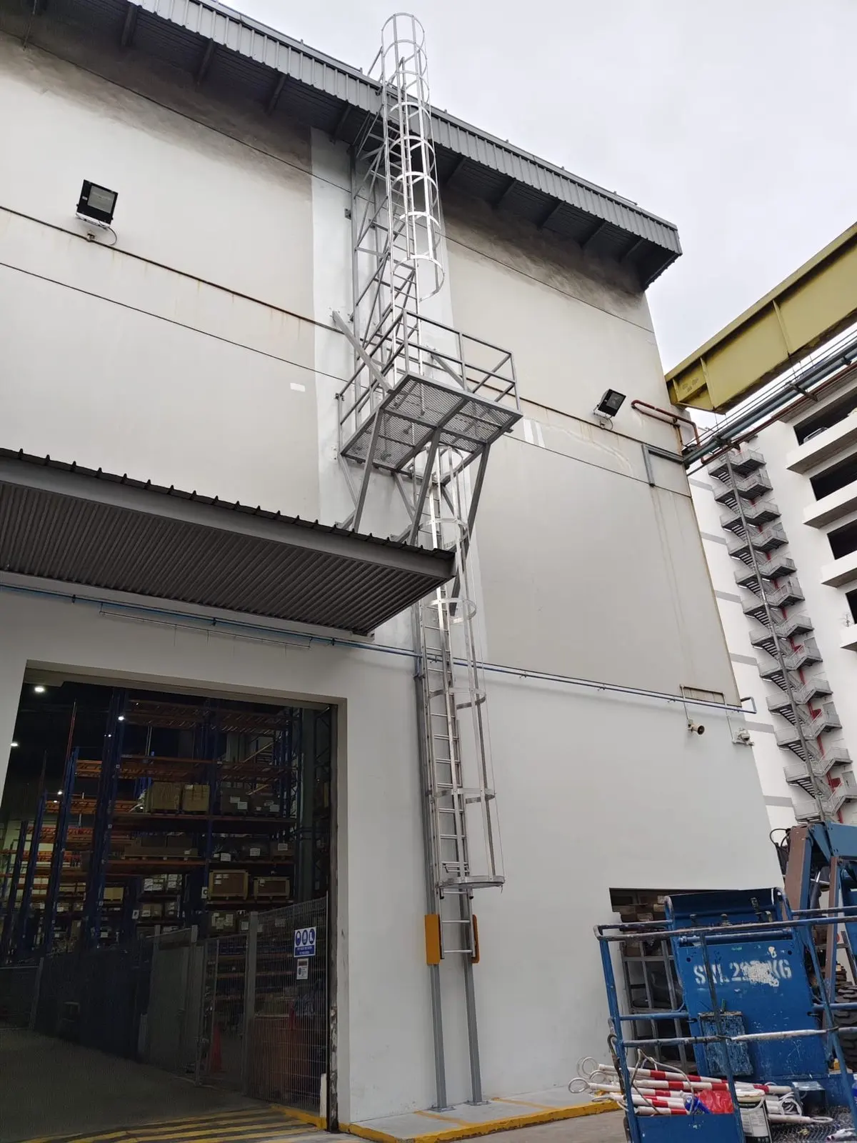 Two cat ladder sets at Buroh Street — lower flight rising to the mid-platform, upper flight continuing to the roof, both with hoop cages