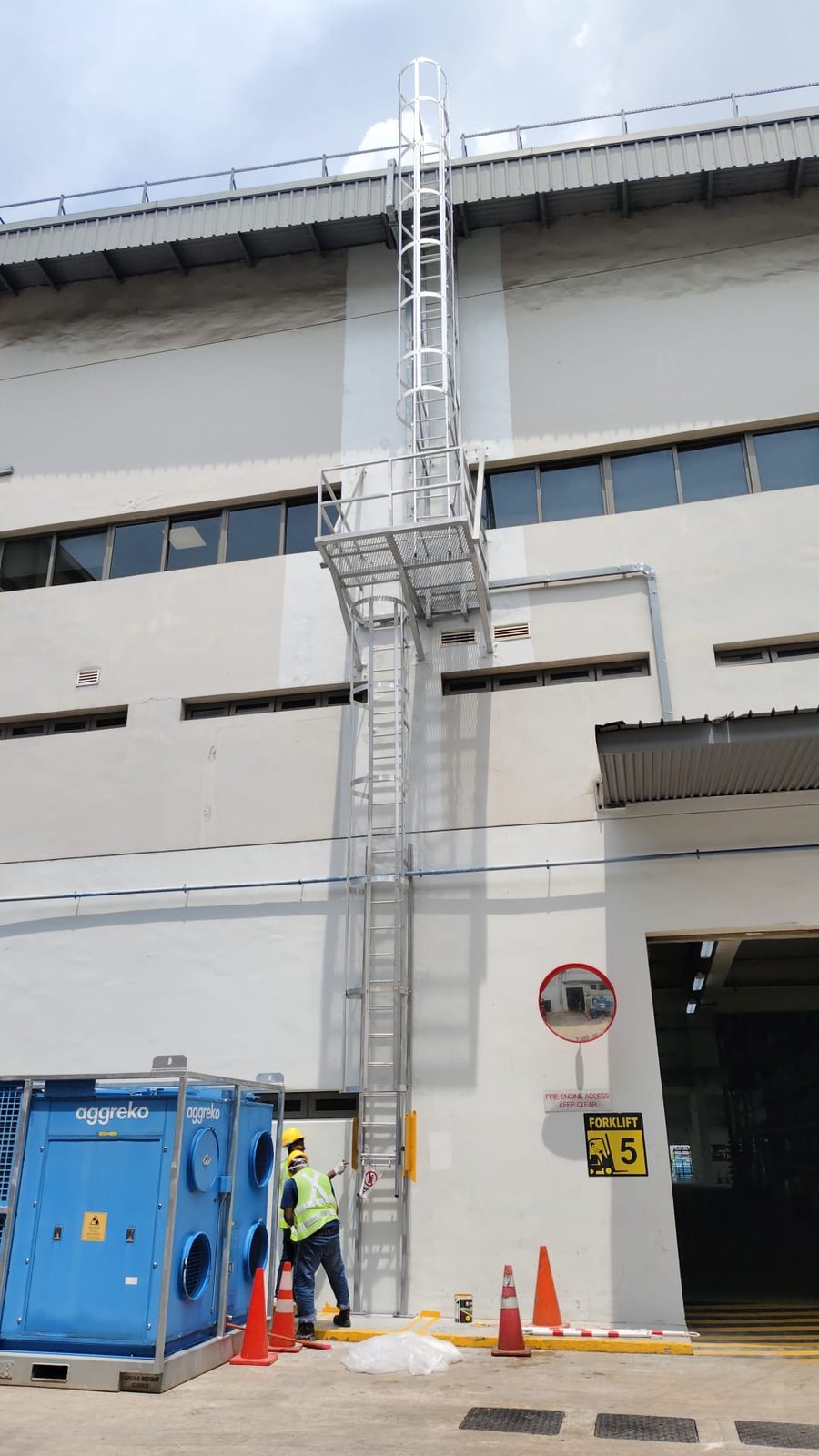 Full-height portrait of the Buroh Street cat ladder showing both flights and the mid-landing, with a worker at the base for scale