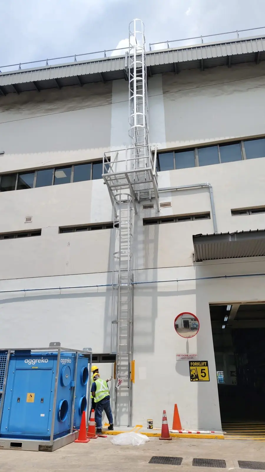 Full-height portrait of the Buroh Street cat ladder showing both flights and the mid-landing, with a worker at the base for scale