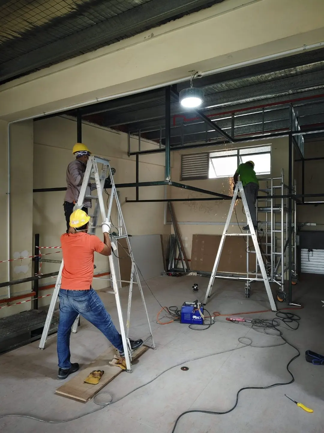 Worker on a step ladder fitting mezzanine steel framing at Frontier Industrial Building