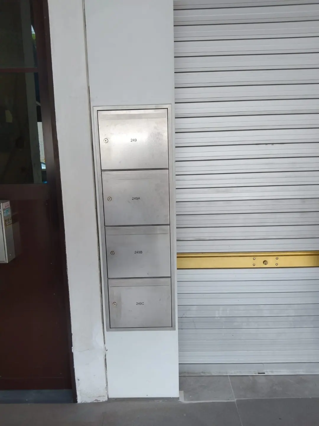 SS304 stainless steel mailbox installed against the wall beside the main entrance corridor at Outram Road