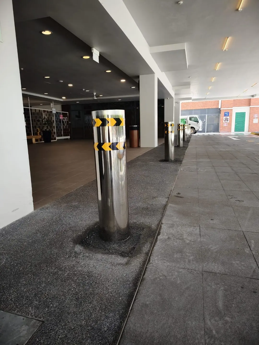On-site fitting and installation view of stainless steel bollards at Rainbow Centre