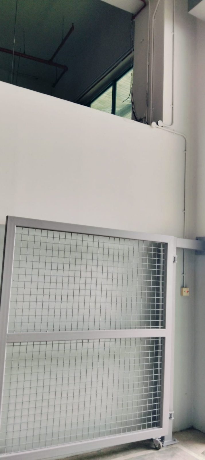 Mid-installation view of the Strides Premier metal gate panel offered up to the opening for fit-up